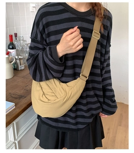 Detail view of khaki nylon dumpling bag with adjustable wide strap for casual wear