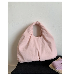 Macro detail of the light pink fabric texture and casual design on a large tote bag