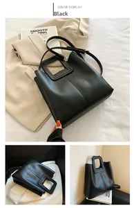Detail of black leather tote bag with unique square cutout handle and stitching