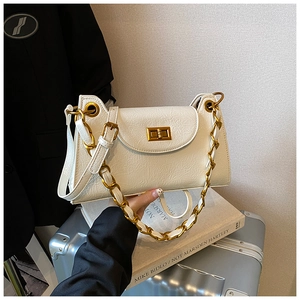 Detail of white wrinkled texture leather bag with elegant gold chain strap and turn-lock