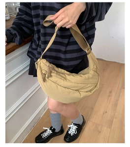 Detail view of khaki quilted crescent bag with adjustable wide shoulder strap for women