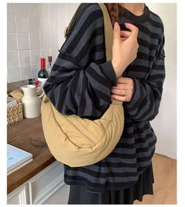 Close-up of beige nylon crescent bag with wide adjustable strap for commuting
