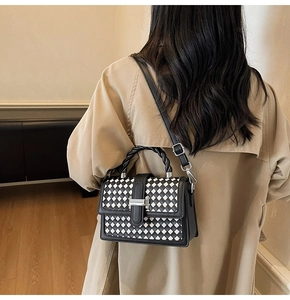 Fashionable woven crossbody bag with black and white checkerboard pattern on a trench coat