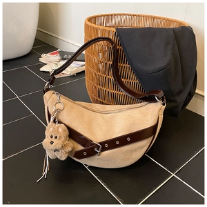 Detail of hobo shoulder bag in beige suede with dark brown leather strap and puppy charm
