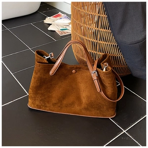 Detail view of caramel brown suede tote bag featuring sturdy handles and adjustable strap
