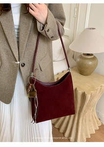 Detail of dark red suede tote bag with heart charms and minimalist retro vibe