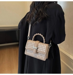 Detail shot of apricot woven square bag texture with twisted handle and metal lock