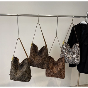 Detail view of large leopard print tote bags in various shades on a metal rack