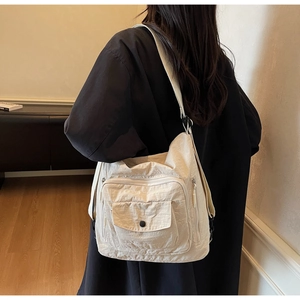 Detail of a beige multi-pocket messenger bag featuring durable nylon and adjustable strap