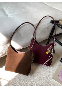Detail view of premium faux suede tote bags in brown and burgundy with soft matte texture