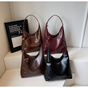 Close-up of vintage glossy PU leather tote bags in various colors on minimalist stairs