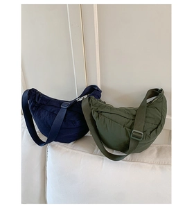 Detail view of nylon crescent bags in navy and olive with adjustable wide straps