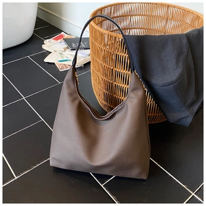 Vue détaillée d'un sac hobo marron foncé avec bandoulière noire et fermeture éclair dorée