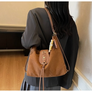 Close-up of vintage brown frosted tote bag with ethnic beads and metal floral clasp