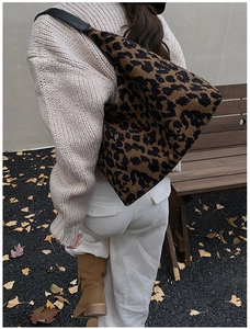 Gros plan d'un sac hobo léopard avec bandoulière noire porté par un mannequin