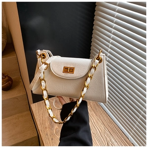 Detail view of the beige faux-leather texture and golden chain strap on this shoulder bag