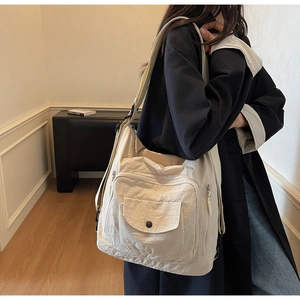 Detail of off-white large canvas tote bag with functional pockets and wide strap