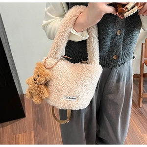 Détail du sac seau beige en polaire avec breloque ours et bandoulière marron