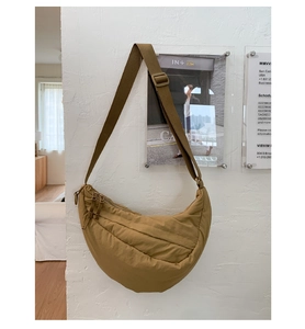 Detail view of khaki crescent shoulder bag with quilted fabric texture and adjustable strap