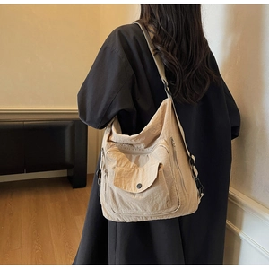 Detail view of khaki tote bag featuring tactical front pockets and adjustable straps