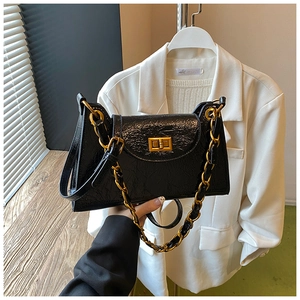 Detail of black pleated shoulder bag with gold chain strap and metallic turn-lock