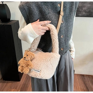 Detail of plush lamb wool handbag in beige with woven strap and cute bear charm