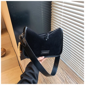Nahaufnahme der schwarzen Veloursleder-Tasche mit Holzperlenquaste und Lederriemen