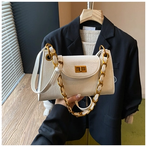 Detail of white pleated texture leather bag with chunky gold chain and metallic buckle