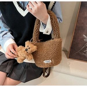 Détail du sac seau en peluche marron avec breloque ours et étiquette logo CLEAR-K