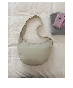 Detailed close-up of light sage green nylon crescent bag with adjustable wide strap