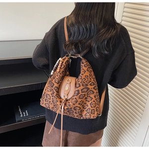 Detail of leopard print tote bag with brown faux leather flap and ethnic tassel charm