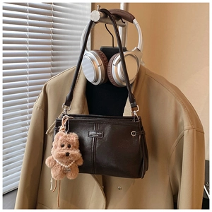 Gros plan d'un sac vintage en cuir marron avec étiquette de marque et porte-clés chien