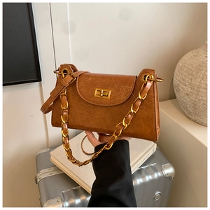 Detail of vintage brown oil wax leather bag featuring golden rotating square buckle