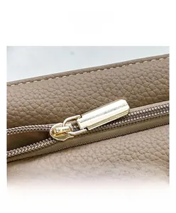 Close-up of premium brown lychee grain leather with high-quality pale gold metal zipper