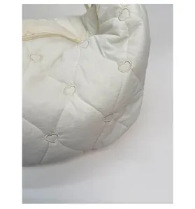 Gros plan détaillé du sac matelassé blanc avec surpiqûres en forme de cœur et zip