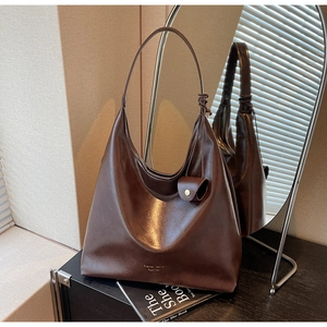 Détail du sac hobo marron foncé au fini brillant avec mini pochette décorative