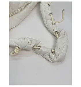 Détail de la bandoulière à cordon avec œillets métalliques et broderie cœur sur sac matelassé