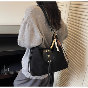 Détail du grand sac cabas vintage en daim noir avec cordon à franges et perles colorées