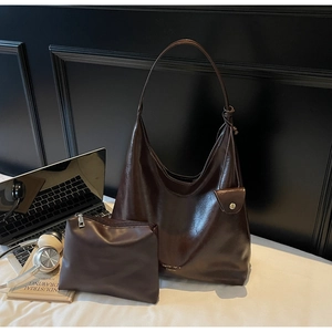 Détail macro du set de sacs cabas en cuir poli marron foncé avec logo de marque doré