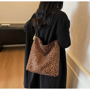 Detail of leopard print tote bag featuring metallic gold lock and spacious interior