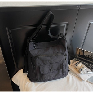 Detail view of large capacity black nylon bag showing multiple pockets and durable textures