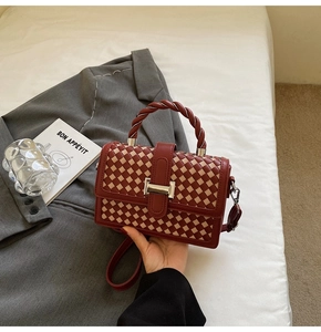 Close-up of red and white checkered woven handbag with silver metal buckle and twist handle