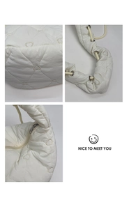 Détails du sac matelassé blanc en forme de cœur avec œillets et fermeture éclair