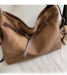 Detail of vintage brown canvas hobo bag with leather straps and silver hardware