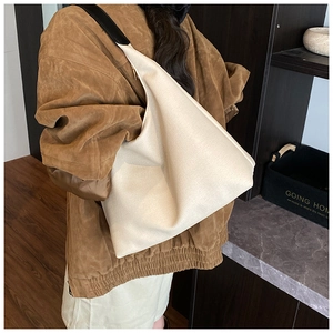 Vue macro du matériau en toile crème texturée et des coutures de ce sac cabas minimaliste