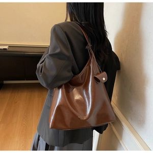 Détail du sac cabas vintage marron avec cordon et petit porte-monnaie sur l'épaule