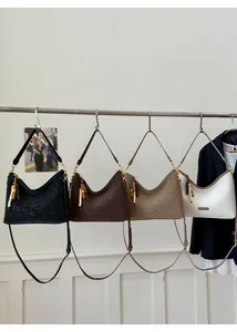 Detail of four retro crescent bucket bags in black, tan, khaki and cream with bead charms