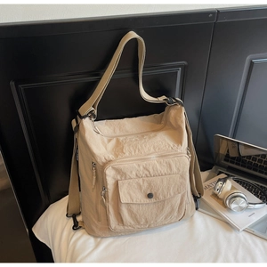 Detail shot of khaki nylon tote bag featuring multi-pocket design and pleated texture