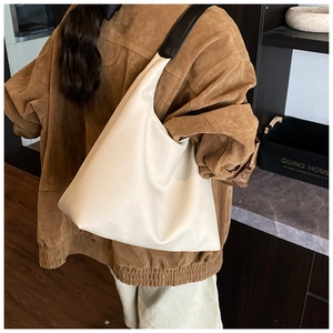 Detailansicht der minimalistischen Hobo-Tasche mit cremefarbenem Stoff und schwarzem Riemen