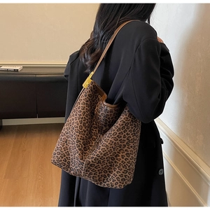 Detail of hobo bag featuring leopard print suede texture and gold metal buckle on leather strap